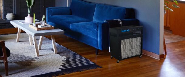 A MAX Guard Air Purifier Cleaning the air in a Living room with blue wall and sofa